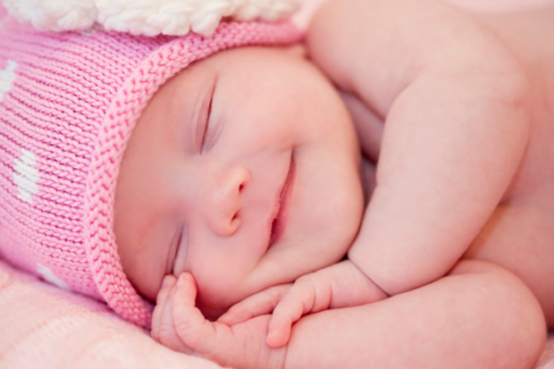 bebé sonríe mientras duerme